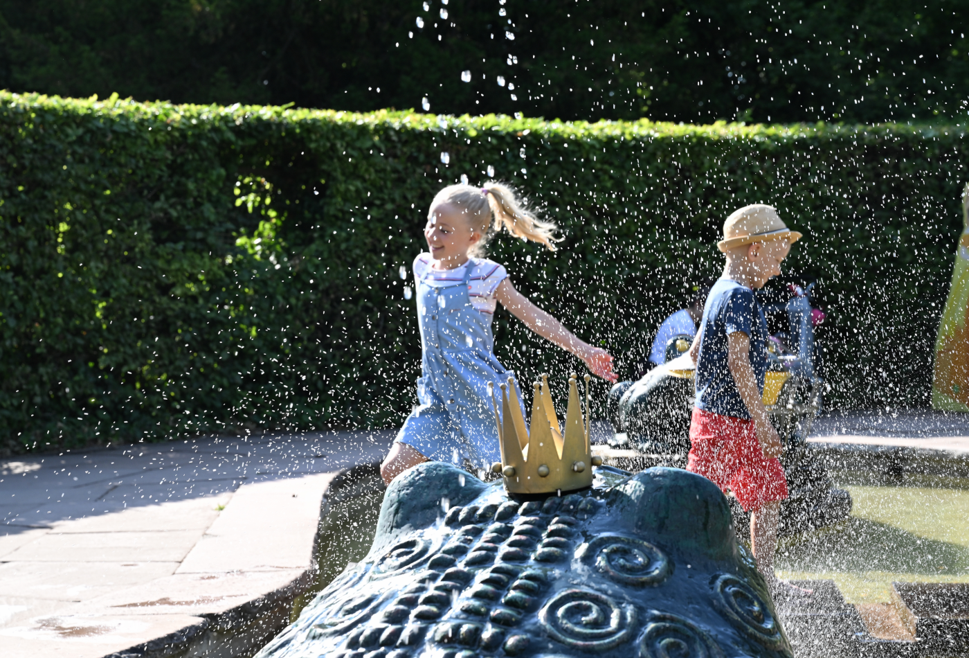 Kinder hüpfen über die Steine beim Froschkönig im Irrgarten