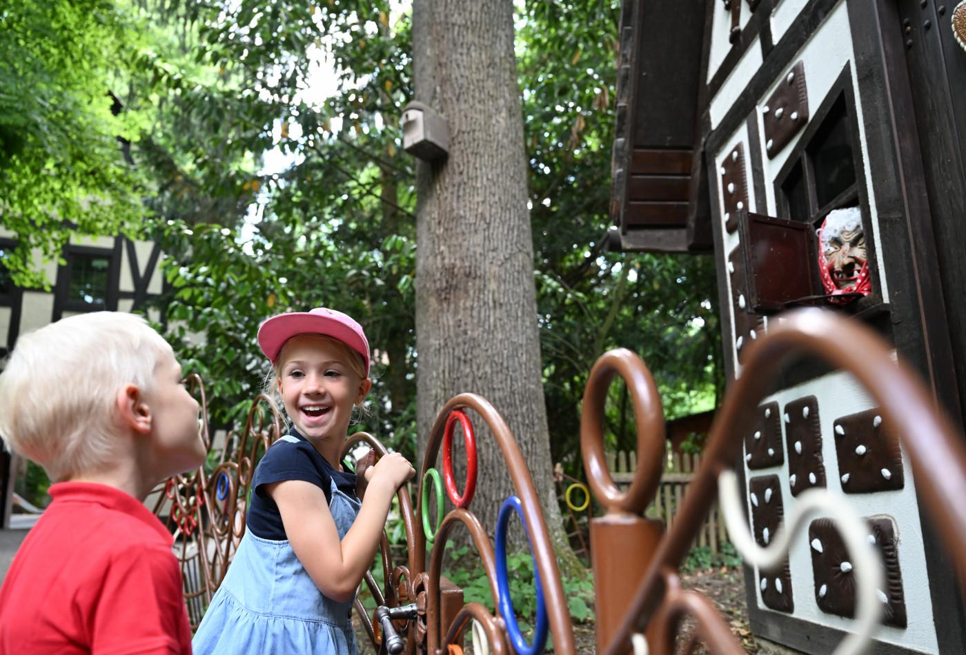 Mädchen und Junge vor dem Hexenhaus von Hänsel und Gretel