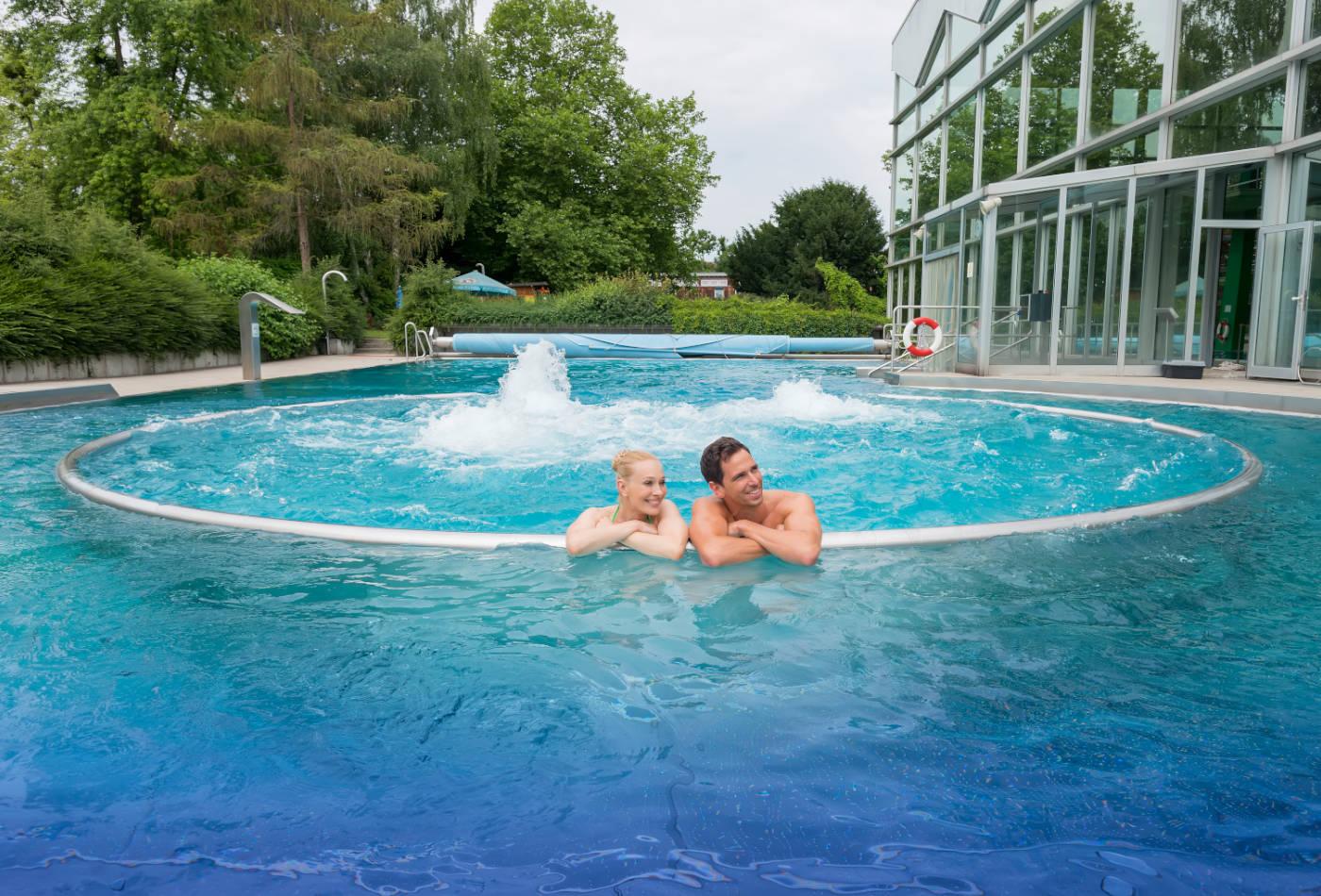 Mann und Frau im Außenbecken des Stadionbads
