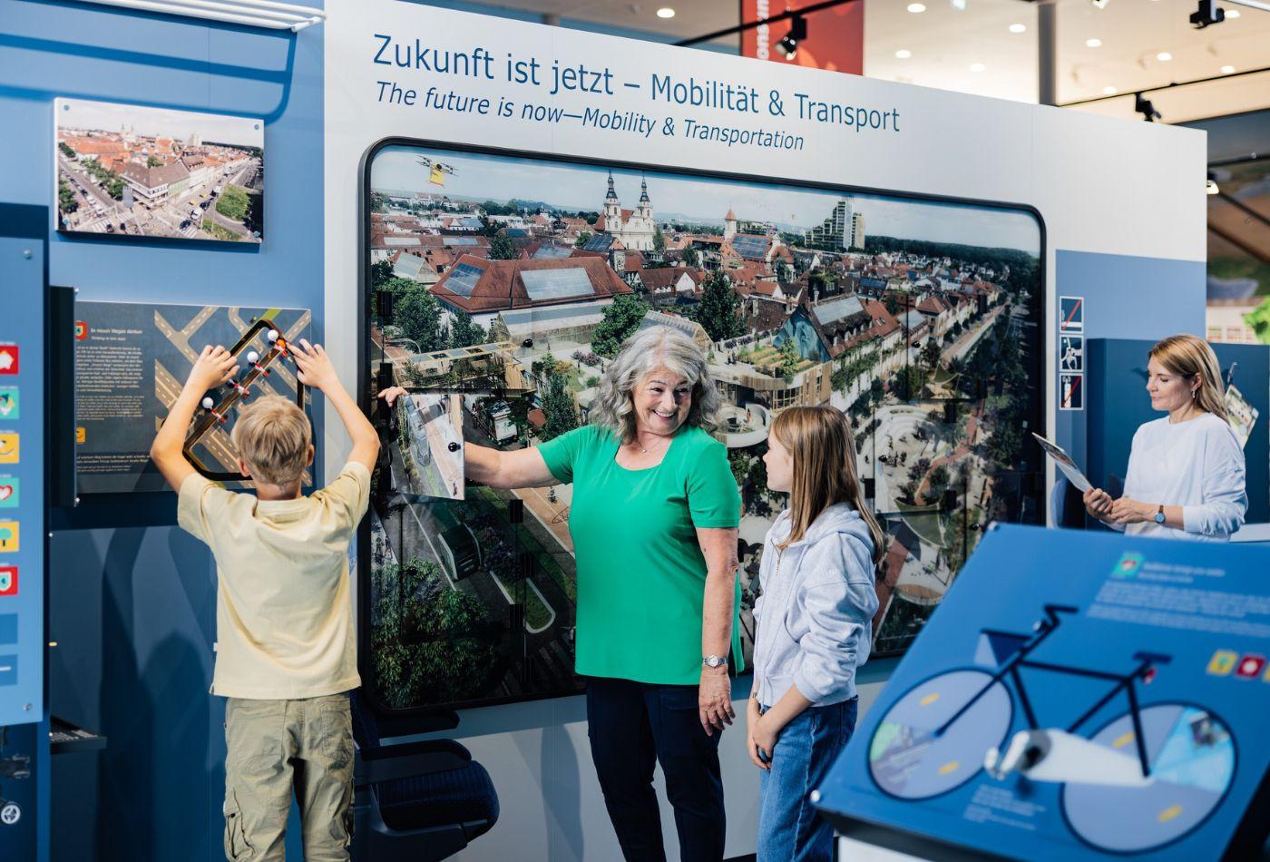 Eine Familie steht an einer Mitmachstation zum Thema Mobilität