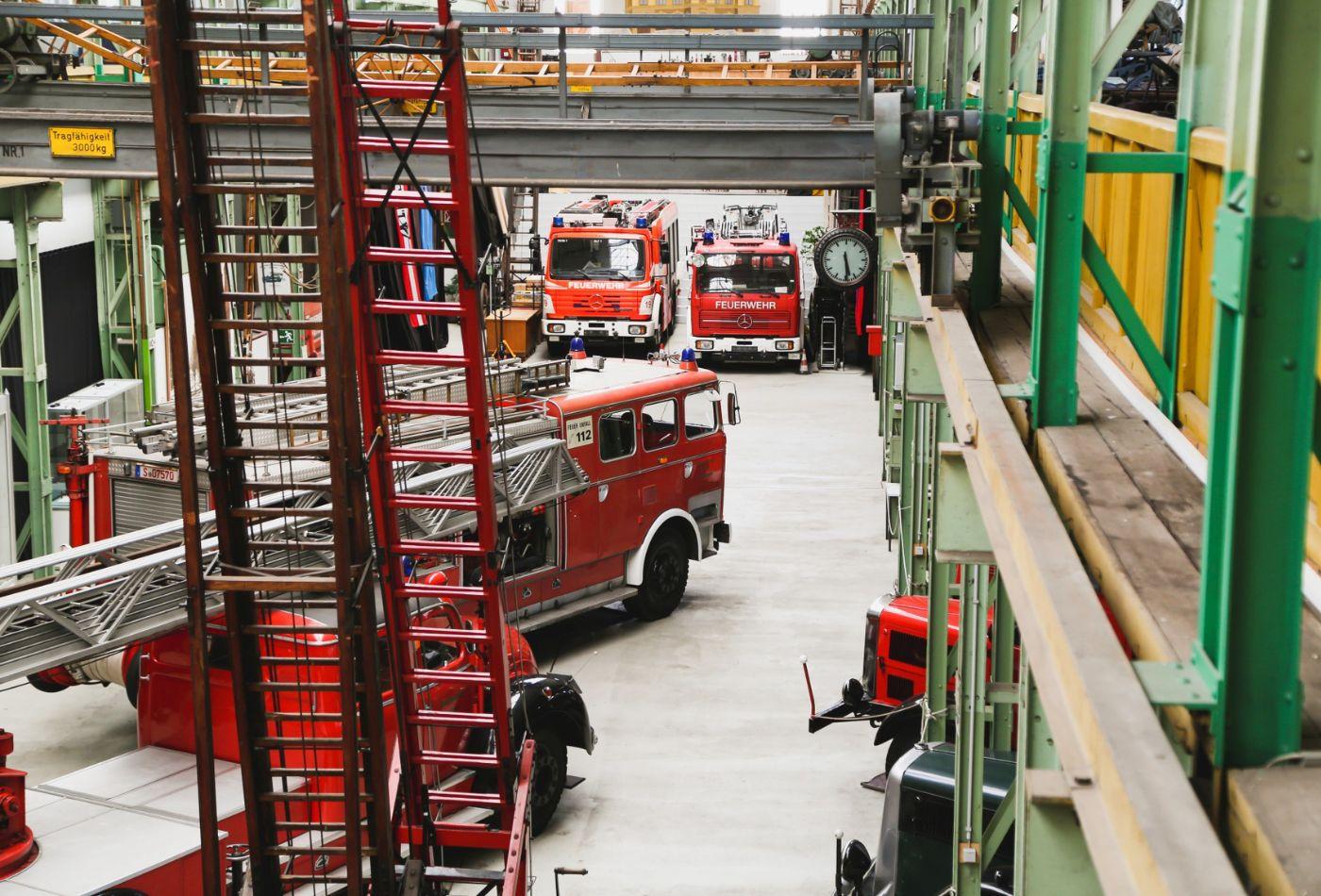 Blick in die Halle des Feuerwehrmuseums auf verschiedene Feuerwehrfahrzeuge und Leitern