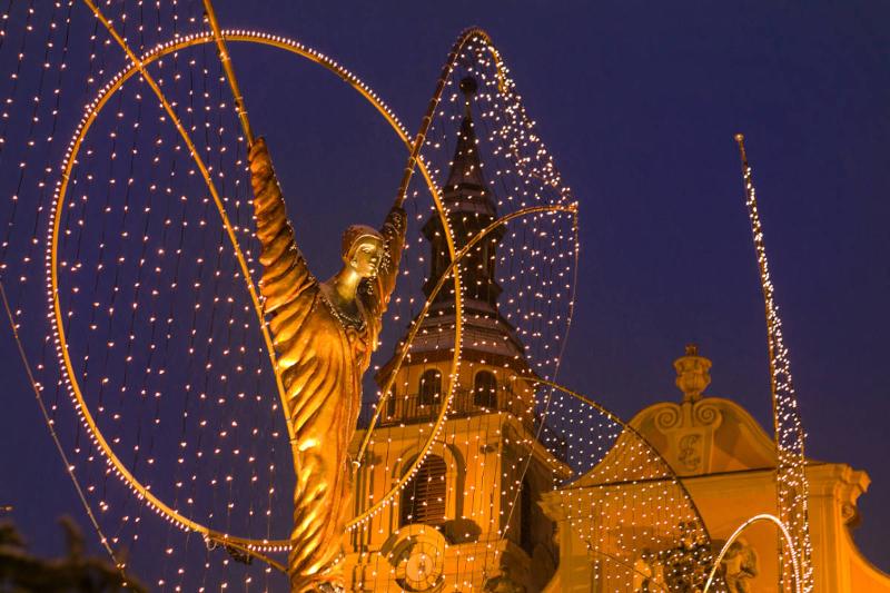 Nachaufnahme der leuchtenden Engel vor der katholischen Kirche bei Nacht.