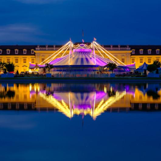 Beleuchteter Circus Roncalli vor dem Residenzschloss zur blauen Stunde