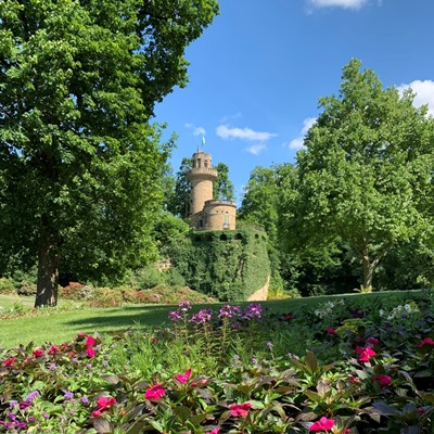 Im Hintergrund die Emichsburg im Blühenden Barock, im Vordergrund ein Blumenbeet.