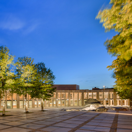 Außenansicht des Forum am Schlosspark bei Dämmerung.