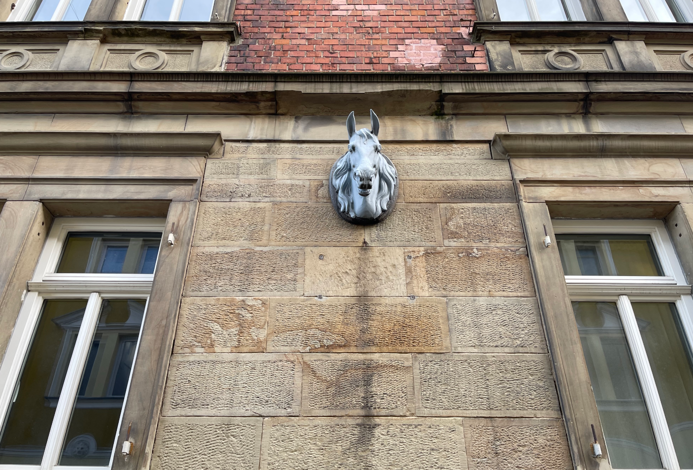 Blick auf Hausfassade mit Pferdekopfskulptur