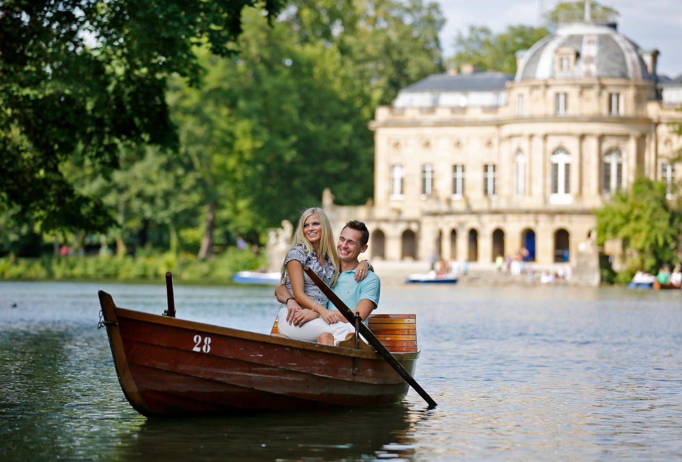 Paar im Ruderboot im Hintergrund das Seeschloss 