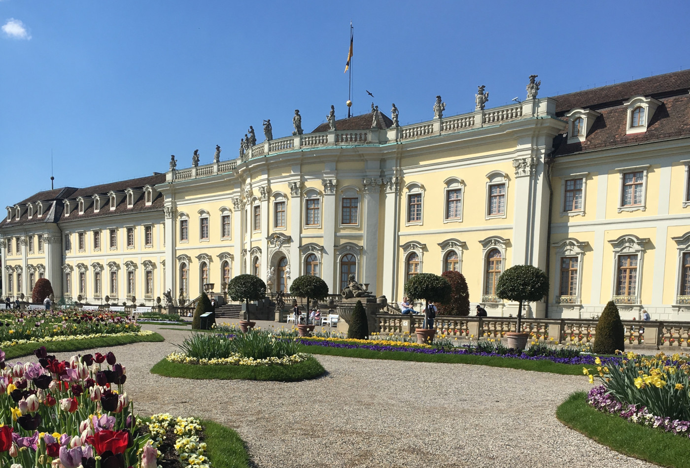 Frontalansicht des Ludwigsburger Residenzschlosses mit Blumen in der Sonne