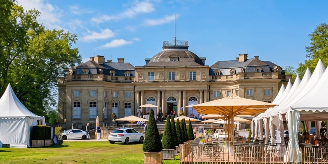 Blick auf das Seeschloss Monrepos mit weißen Pavillons im Vordergrund