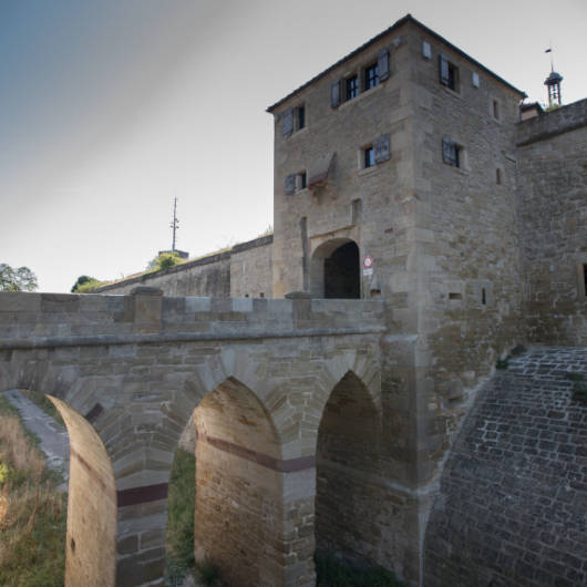 Burggemäuer, Brücke und Turm in stimmungsvollem Licht.