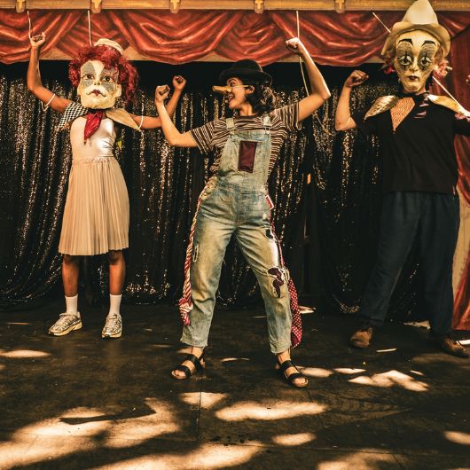 Drei Schauspieler mit Masken auf einer Bühne