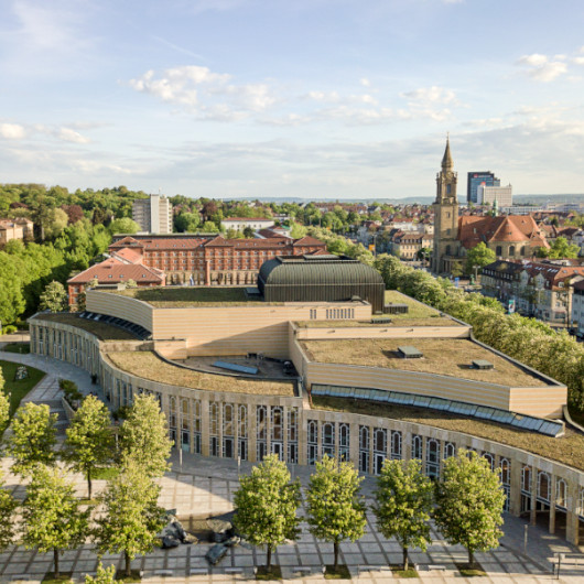 Luftaufnahme vom Forum am Schlosspark mit grünen Bäumen und blaubem Himmel.