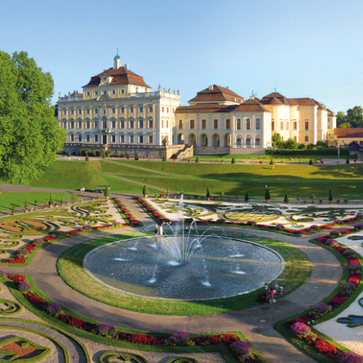Im Vordergrund ist ein Teil der Gartenanlage zu sehen, im Hintergrund ist die Nordseite Residenzschlosses zu erkennen.