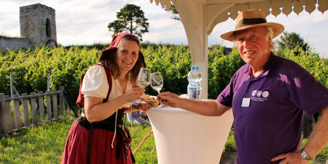 Zwei Guides stoßen mit einem Glas Wein an.