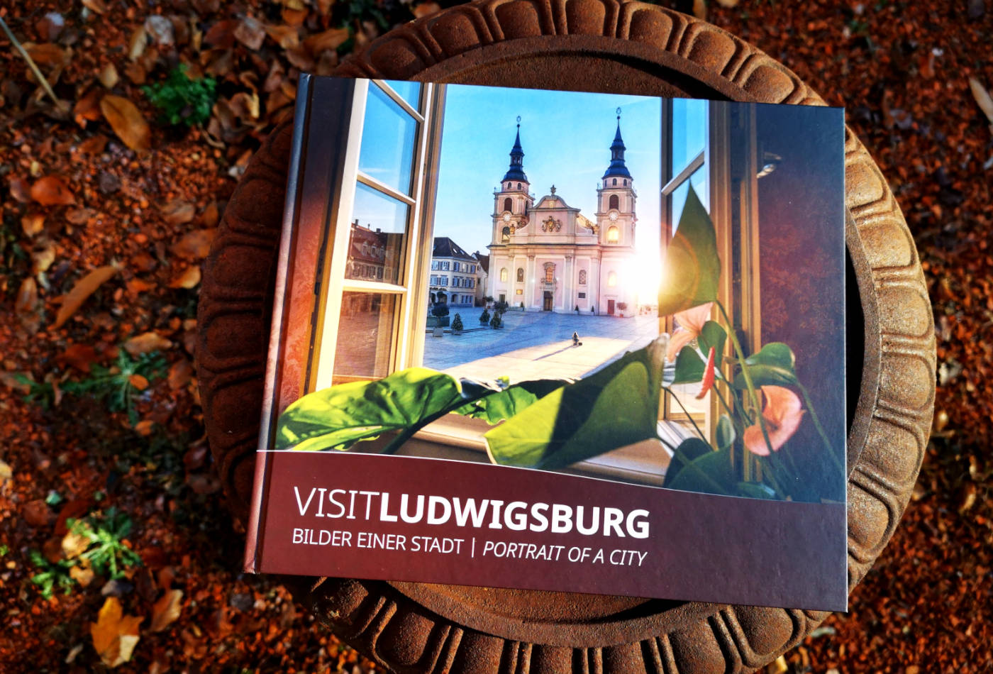 Ein Buch mit einer Kirche auf dem Titel, die aus einem offenen Fenster heraus fotografiert wurde.