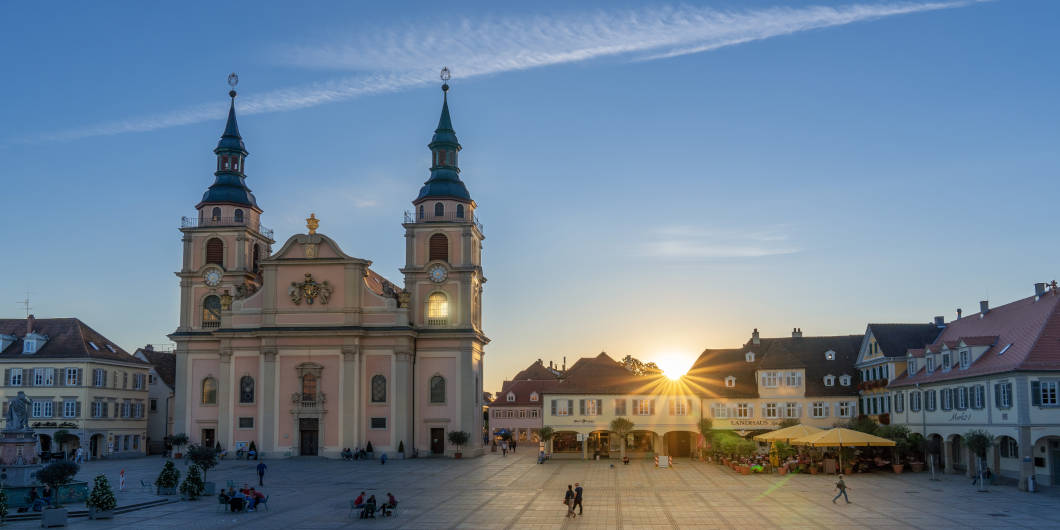 Belebter Marktplatz im Abendlicht mit Evangelischer Stadtkriche im Fokus.