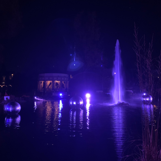 Kunstinstallation mit Licht in Lila auf dem Wasser