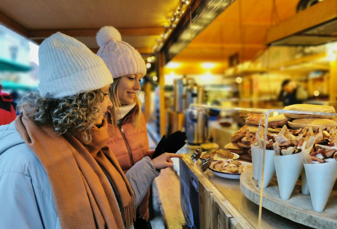 Zwei Frau schauen sich Waren am Marktstand an
