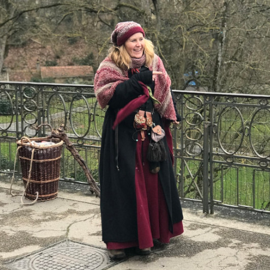 Frau schaut hinter Baum vor