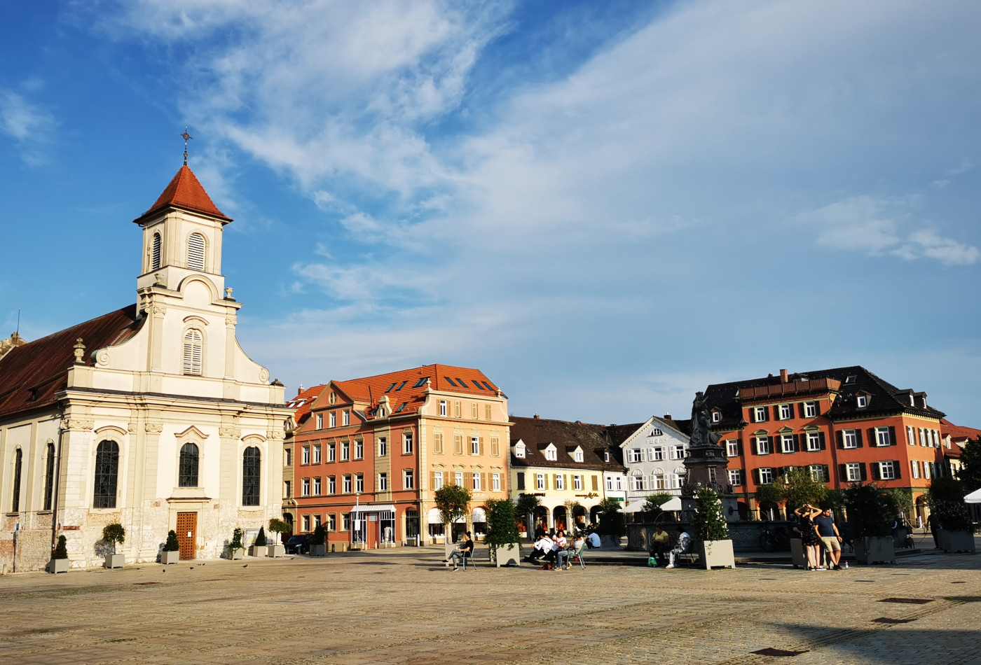 Marktplatz Vordergrund Außenbestuhlung Restaurant, im Hintergrund Evangelische Stadtkirche.