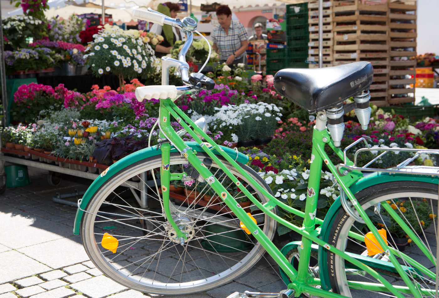 Grün lackiertes Fahrrad vor einem Wochenmarktstand