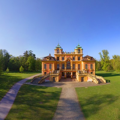 Das Jagd- und Lustschloss Favorite auf einer grünen Wiese umgeben von Bäumen.