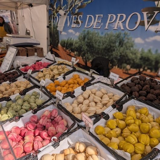 Bunte Macarons an einem Verkaufstand auf dem Französischen Markt
