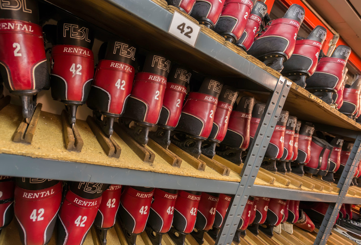 rot-schwarze Leihschlittschuhe nebeneinander im Regal