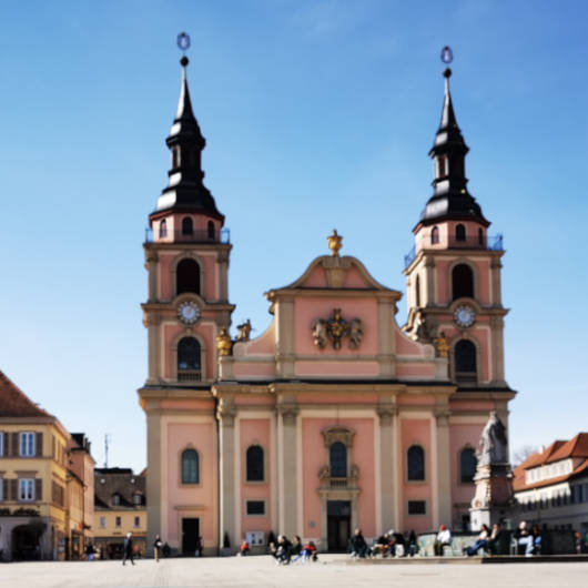 Blick auf die roséfarbene evangelische Stadtkirche mit ihren zwei markanten Türmen.