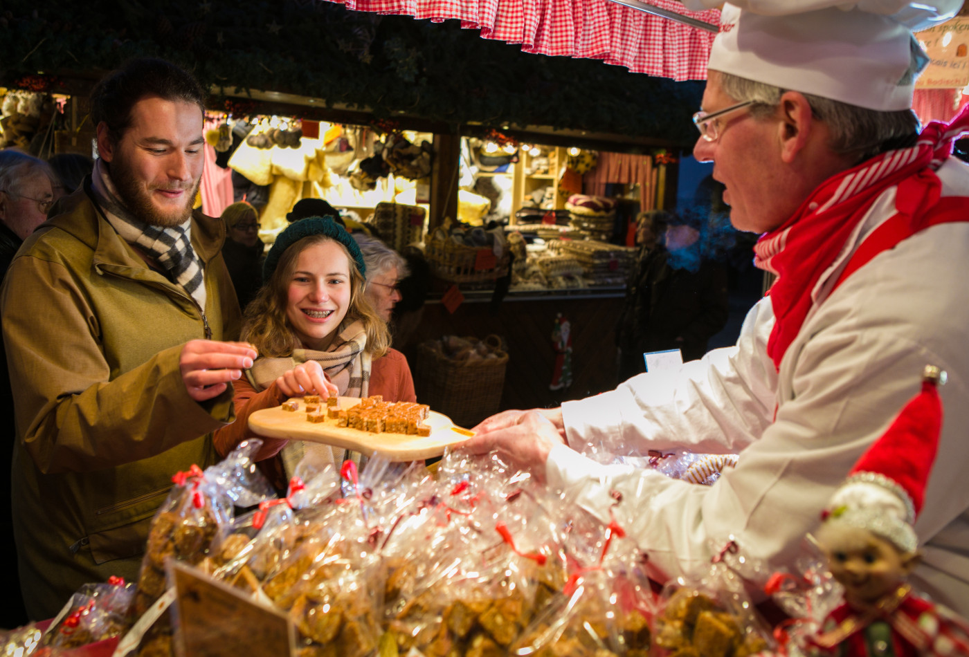 Paar erhählt eine Kostprobe an Weihnachtsmarkt-Hütte