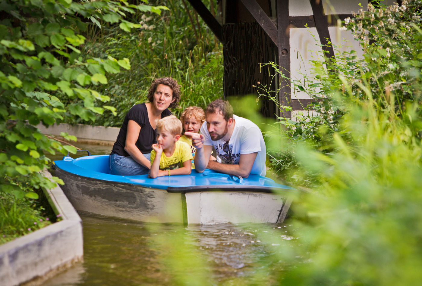 Famililie in einem Boot auf einem Bach im Märchengarten