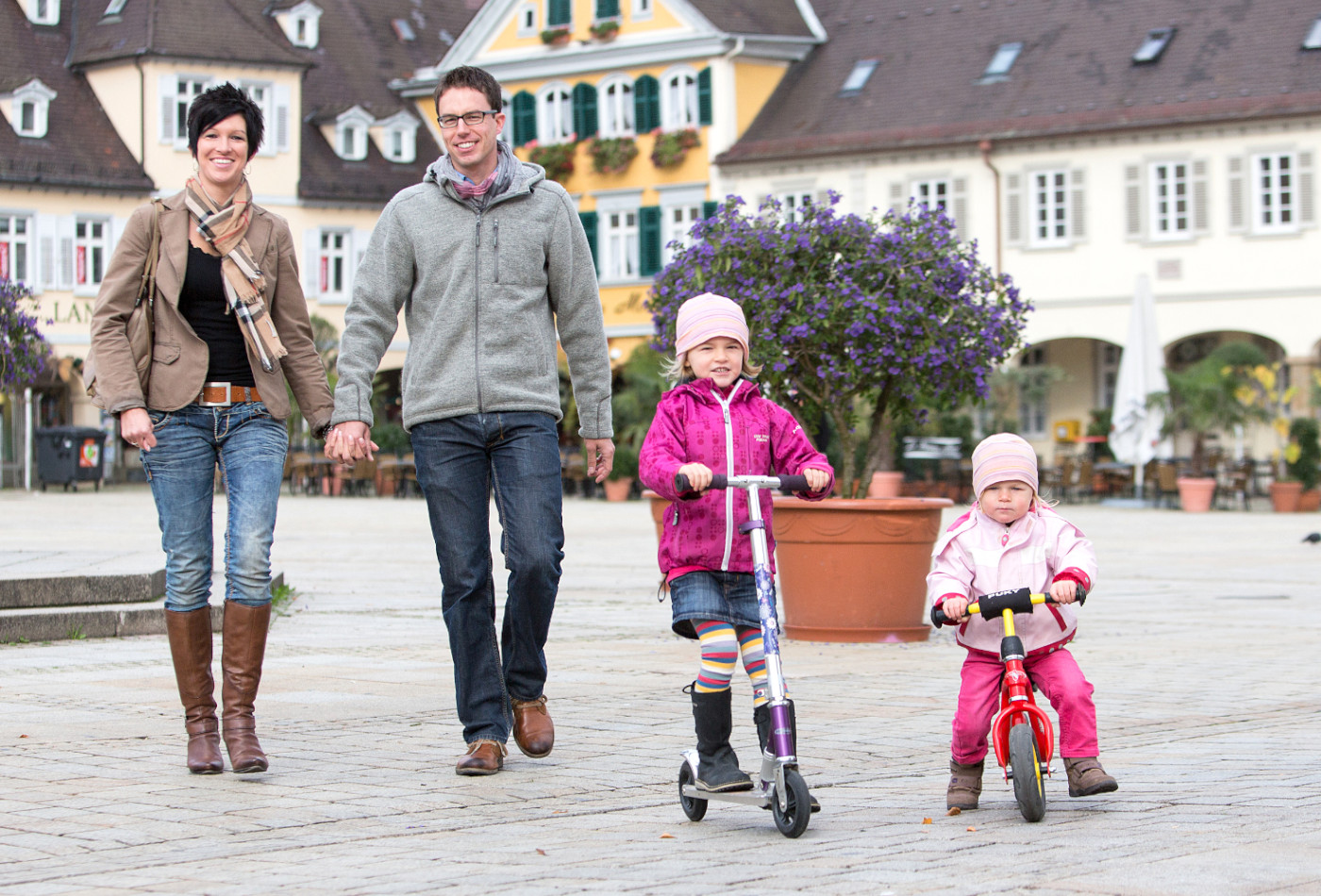 Familie mit zwei Kindern schlendert über den Marktplatz.