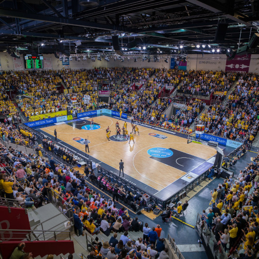 Innenraum der MHPArena bei einem Basketballspiel mit Publikum.