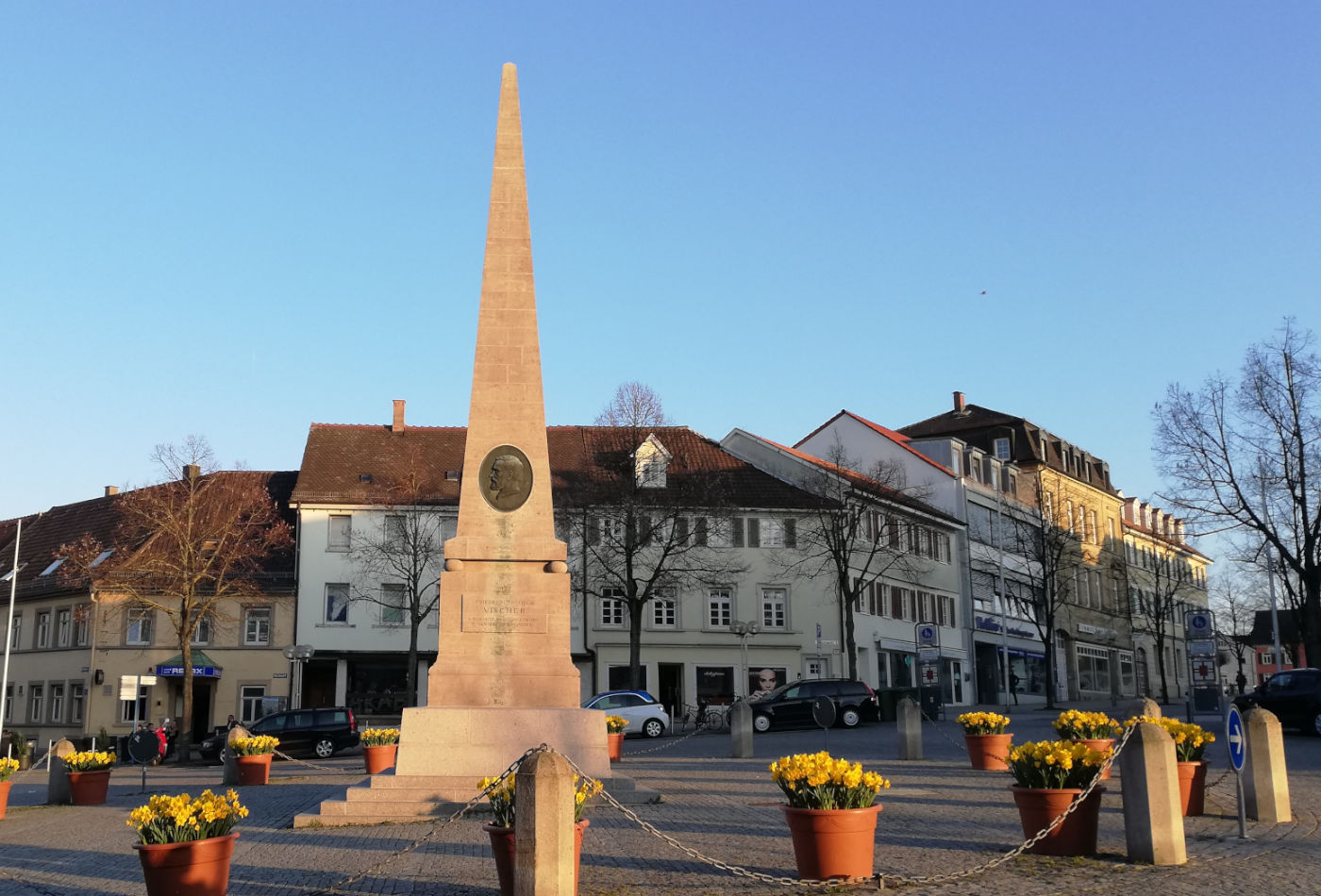 Obelisk mit Blumentöpfen im Vordergrund