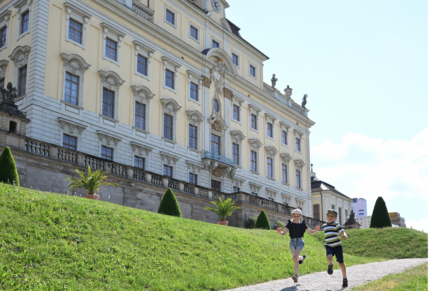 Kinder am Eingang zum Blüba mit einem Fernglas in der Hand.