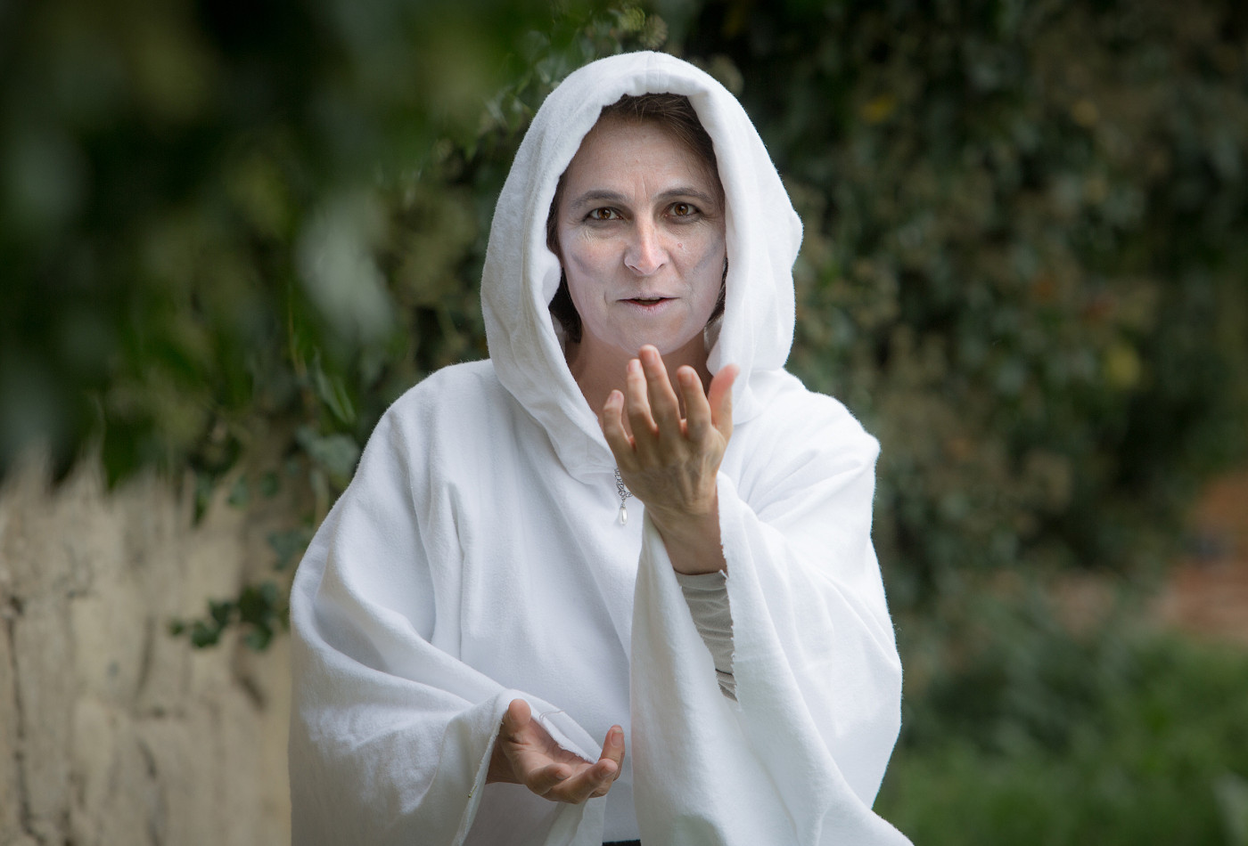 Die Geisterfrau steht in weißem Gewand in der Mitte des Bildes und lockt den Betrachter zu sich.