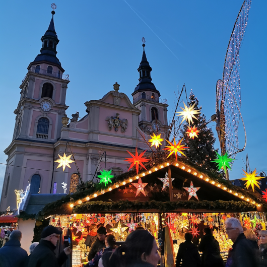 Zu sehen ist ein Stand des Barock-Weihnachtsmarktes Ludwigsburg vor der evangelischen Stadtkirche.