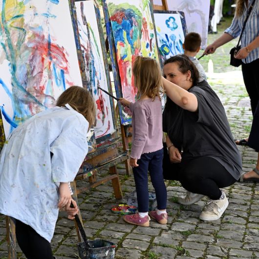 Kinder stehen vor Staffeleien und malen ein Bild