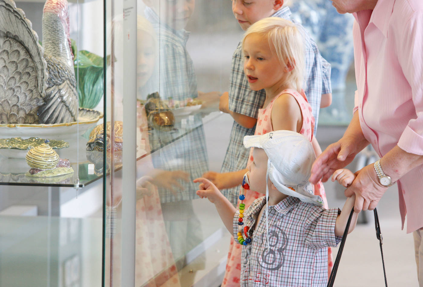 Kinder schauen auf prunkvolle Auslagen im Keramikmuseum