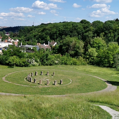 Eine grüne Wiese, inmitten eine Sonnenuhr aus großen Steinen.